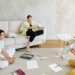 A family enjoying creative activities together in a bright living room setting.